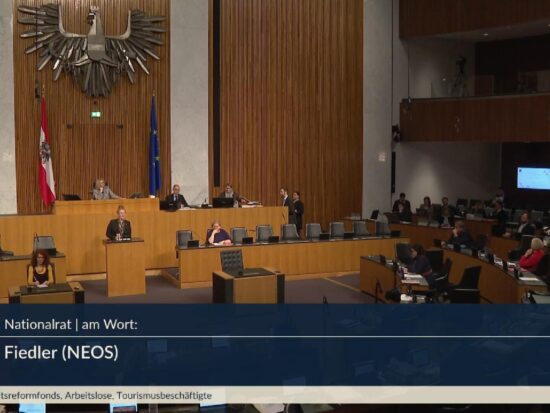 Fiona Fiedler hält ihre Rede im ungewöhnlich finsteren Nationalratssahl. AUf der Regierungsbank hört Corinna Schumann zu.